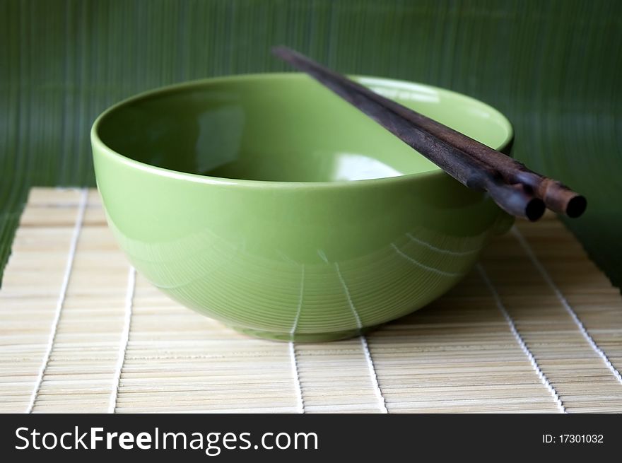 Green bowl and chopsticks on Bamboo pad. Green bowl and chopsticks on Bamboo pad.