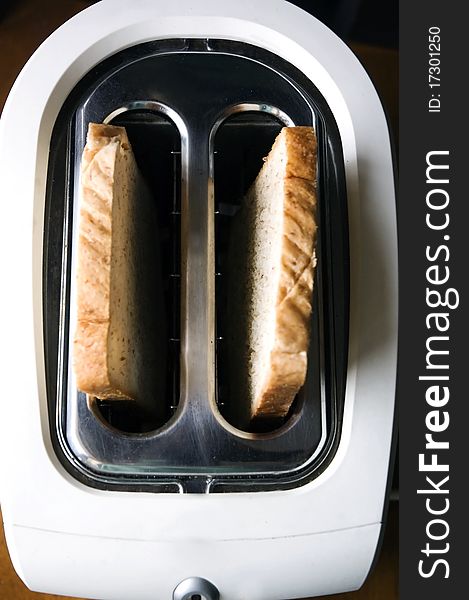 Wheat bread on top in white toaster.
