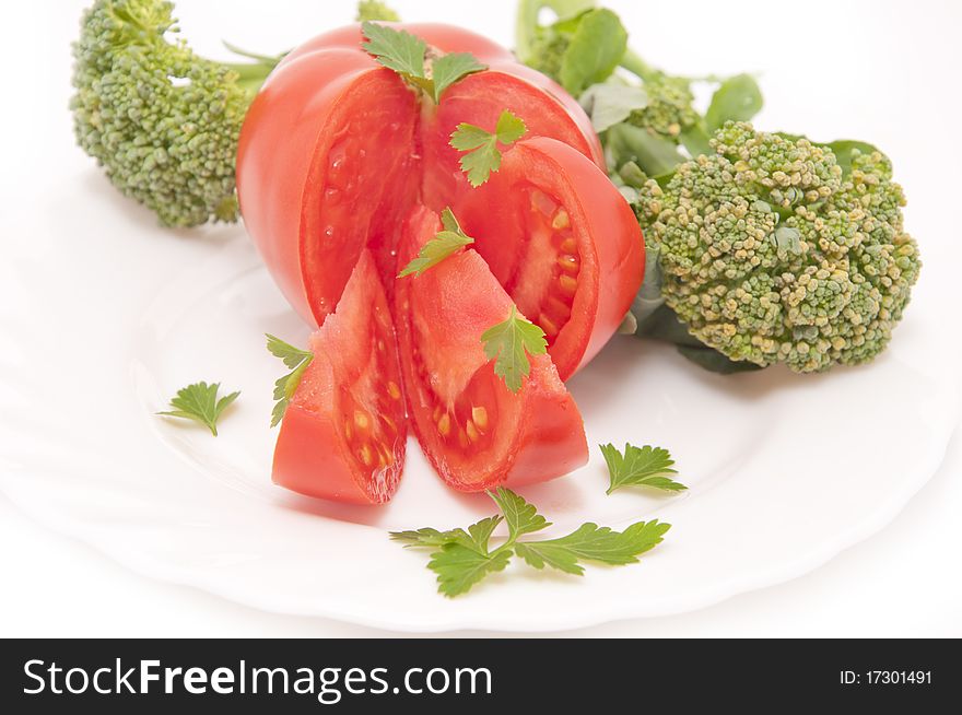 Tomatoes and parsley, served on white plate. Tomatoes and parsley, served on white plate