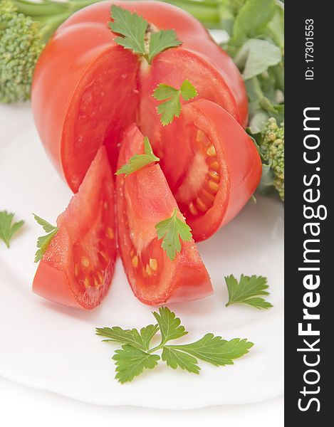 Tomatoes and parsley, served on white plate. Tomatoes and parsley, served on white plate
