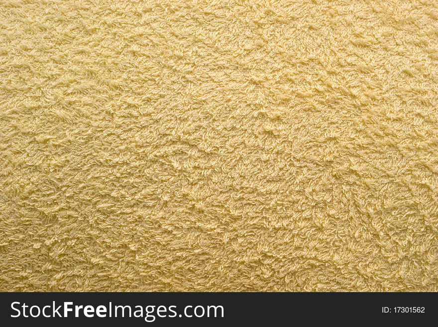 The background of textured light yellow synthetic fabric closeup