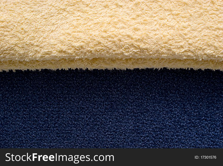The background of textured light yellow and blue fabric closeup