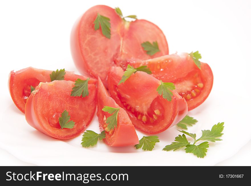 Tomatoes and parsley, served on white plate. Tomatoes and parsley, served on white plate
