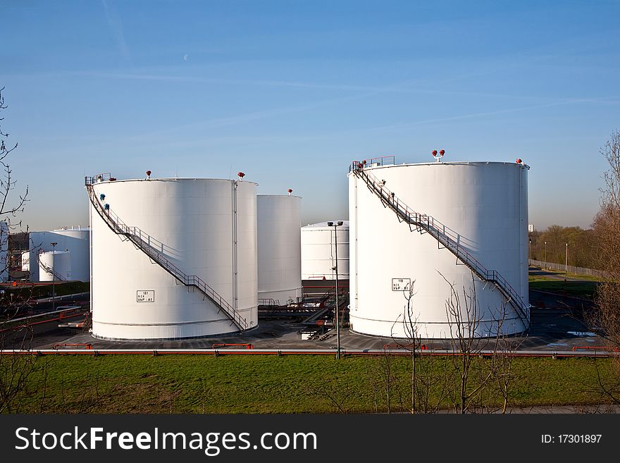 White tanks in tank farm with blue clear sky