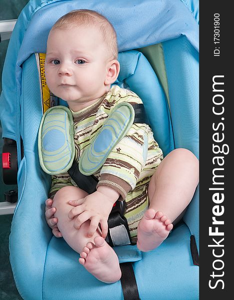 To the child seven months, he sits in a children's automobile armchair. To the child seven months, he sits in a children's automobile armchair.