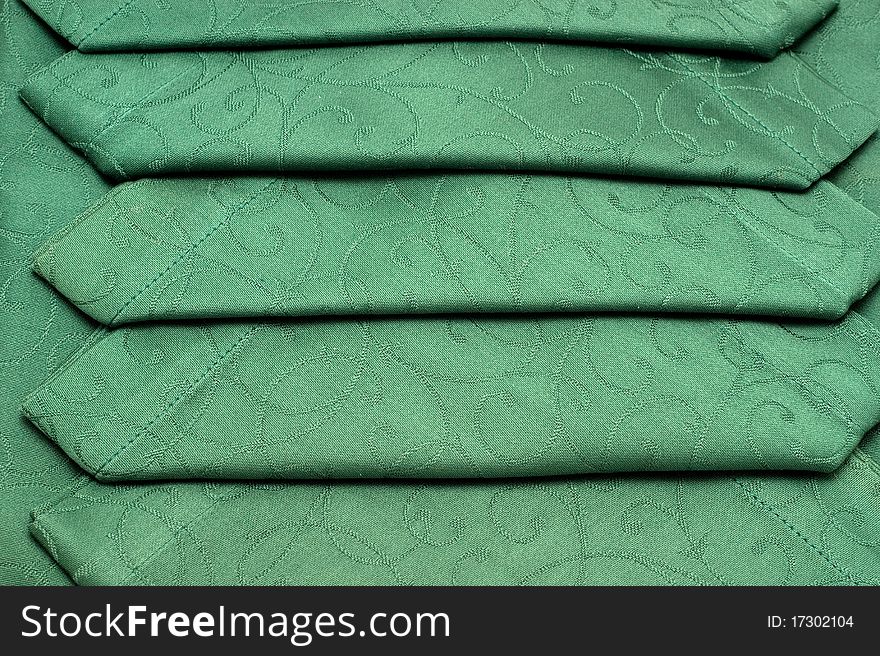 The background of textured green tablecloth and napkin closeup