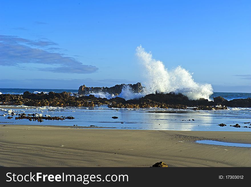 A huge wave crashes on the rocks early in the mornng. A huge wave crashes on the rocks early in the mornng