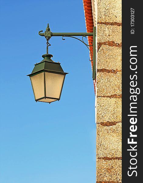 Ancient wall street green lamp with blue sky as background. Ancient wall street green lamp with blue sky as background