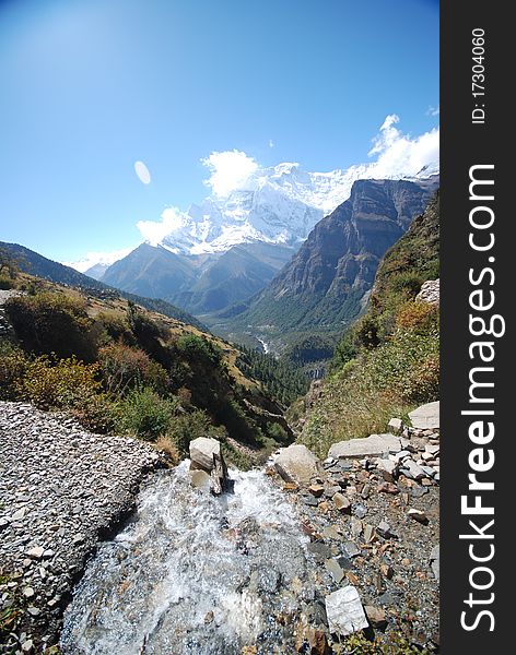 small stream with mountains in the background