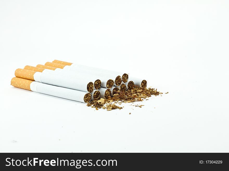 Spilled tobacco and cigarettes isolated on white