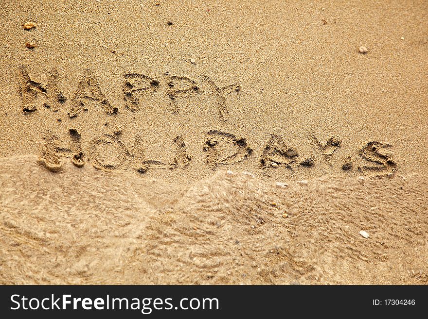 Inscription happy holidays on a sand. Inscription happy holidays on a sand