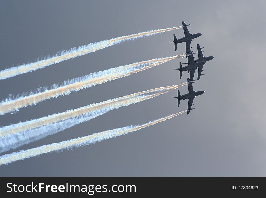 Aerobatic jet planes performing maneuvers during an air show.