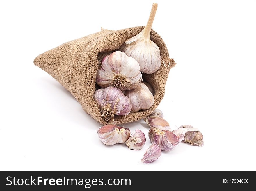 Burlap sack with garlic on white