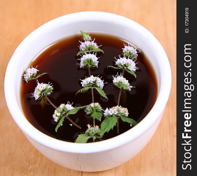 White bowl of tea with mint twigs. White bowl of tea with mint twigs