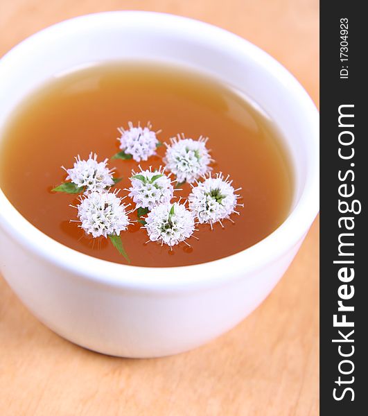 White bowl of green tea with mint twigs