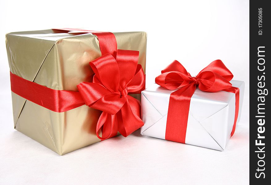 Gifts in silver and gold wrapping with red bow