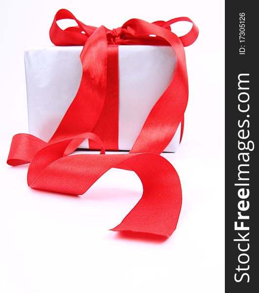 Gift in silver wrapping with red bow