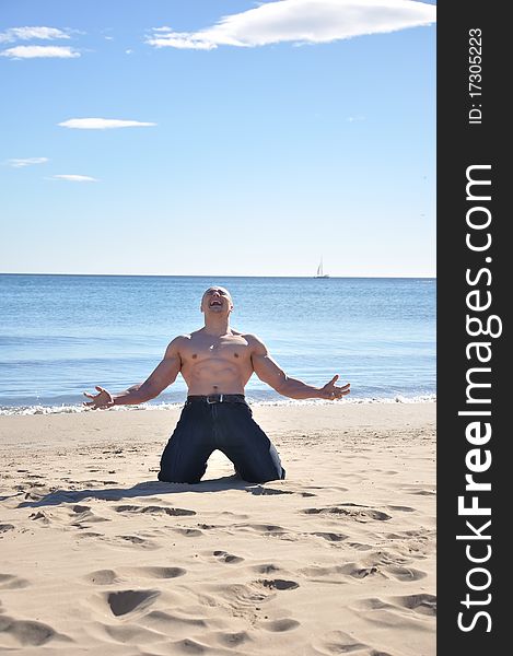 Muscular man kneel on beach and screaming. Muscular man kneel on beach and screaming