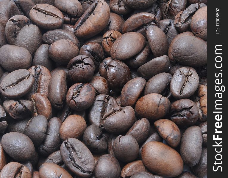 Picture of grains of lying black coffee with focus in the middle. Picture of grains of lying black coffee with focus in the middle