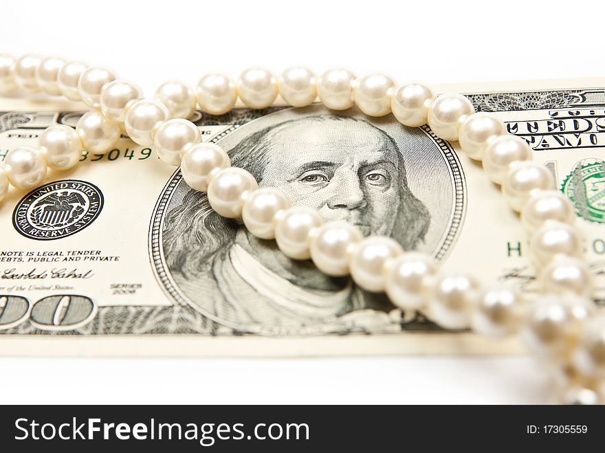 Pearls and dollars on white background