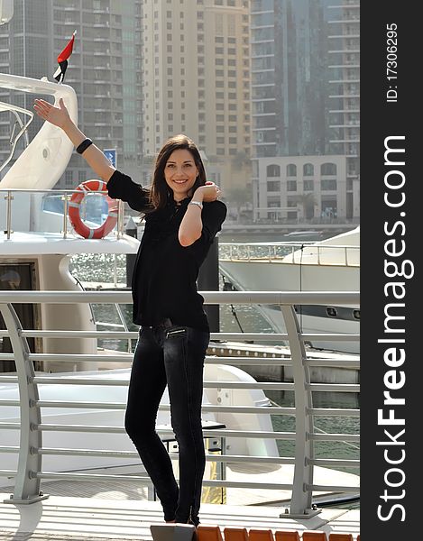 Young smiling woman pointing on quay. Young smiling woman pointing on quay