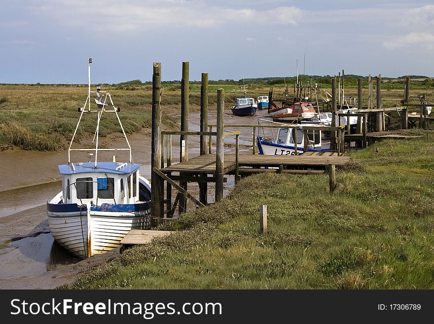 Boats At Low Tide In A Channel On The Coast