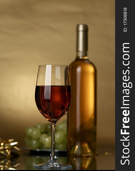 Bottle of white wine and white grapes on a yellow background