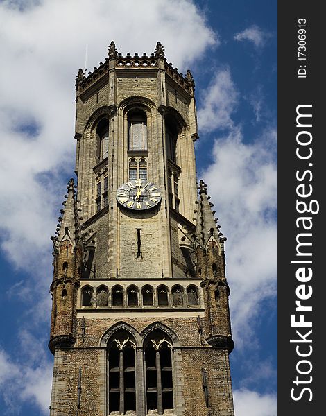 Brugge, Belgium - The famous Belfort Tower in the daytime with blue sky and clouds. This building is located at the head of the market square. Brugge, Belgium - The famous Belfort Tower in the daytime with blue sky and clouds. This building is located at the head of the market square.