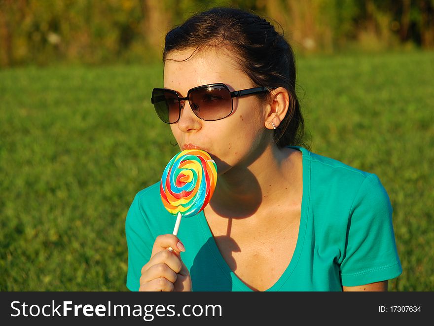 The girl is eating a lollipop