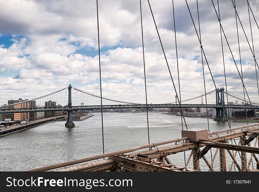 New York City Brooklyn Bridge in Manhattan closeup with skyscrapers and city skyline over Hudson River.