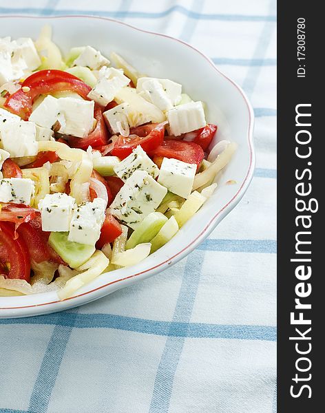 Delicious bowl of greek style salad, with tomato, onions, feta cheese and corn. Delicious bowl of greek style salad, with tomato, onions, feta cheese and corn