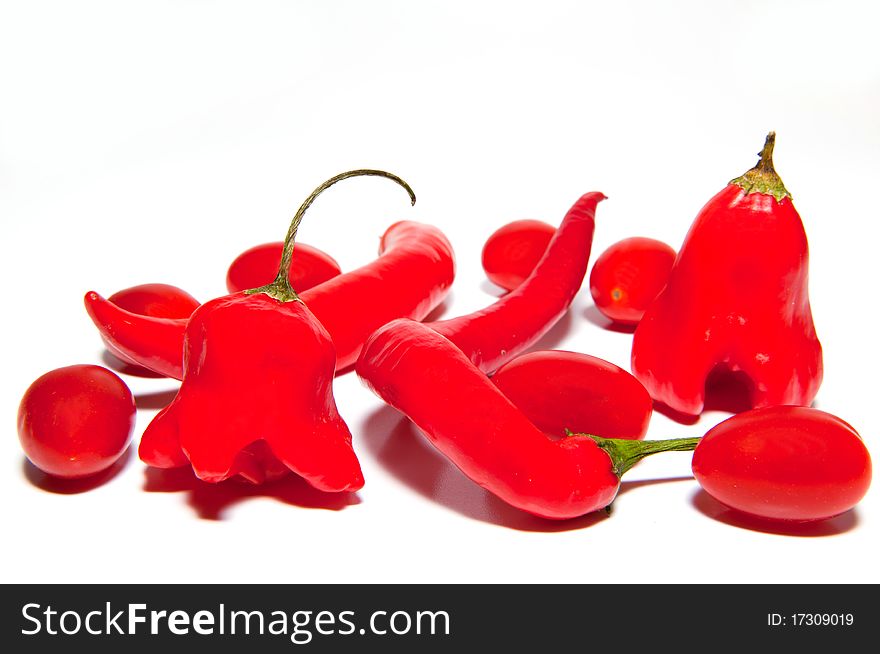 Red hot chilli peppers and cherry tomatoes isolated on a white background.