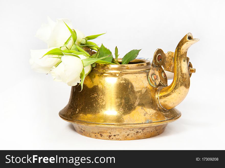 Old teapot with white roses on the white background