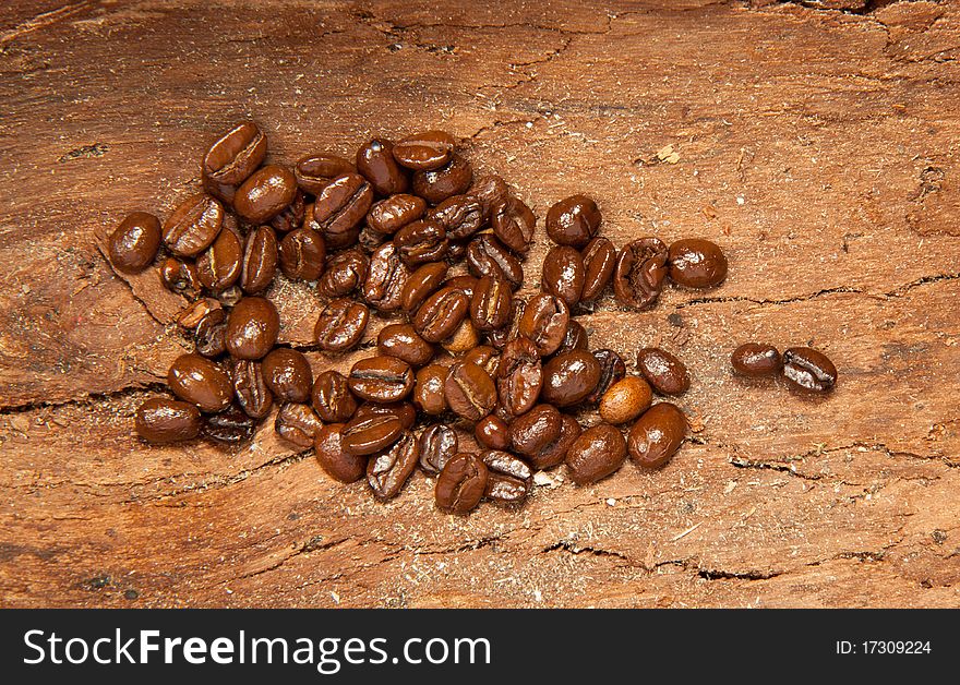 Fragrant fried coffee beans on the old wooden desk