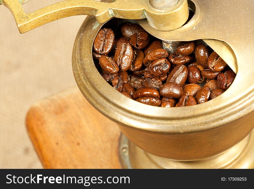 Fragrant fried coffee beans in the wooden old-style coffee grinder. Fragrant fried coffee beans in the wooden old-style coffee grinder