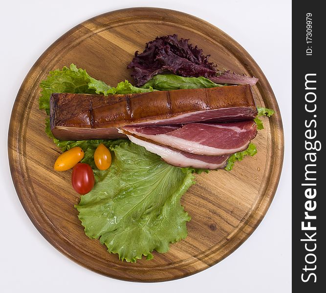 Breakfast close-up. Slices of bacon on the wooden plate with knife