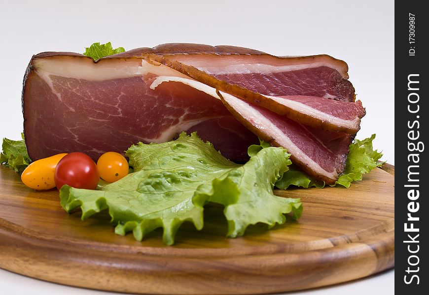 Breakfast close-up. Slices of bacon on the wooden plate with knife