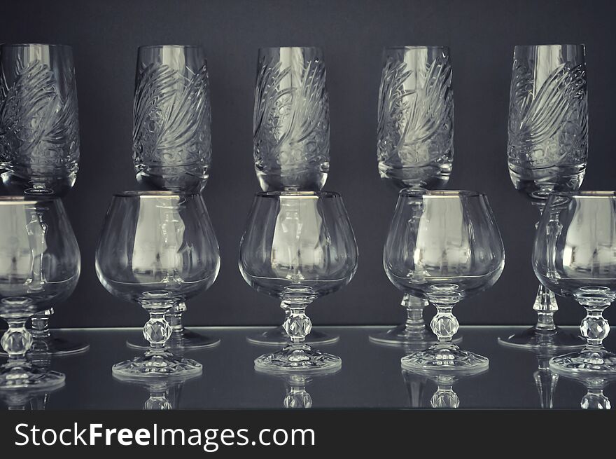 Stylish glasses for alcohol on a dark background. Beautiful crystal tableware. Stylish glasses for alcohol on a dark background. Beautiful crystal tableware.