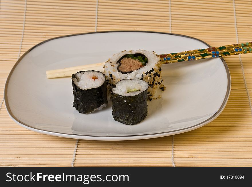 Japanese Sushi on white plate with chopsticks