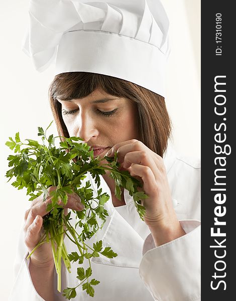 Female Chef Smelling Parsley, white background