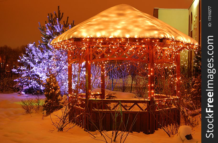 Garden under snow adorned with Christmas garlands. Garden under snow adorned with Christmas garlands