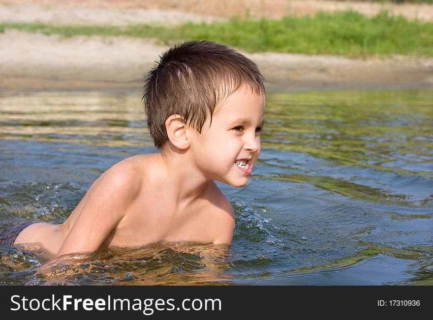 Portrait of the boy in the river, bathing and having a rest actively on the nature