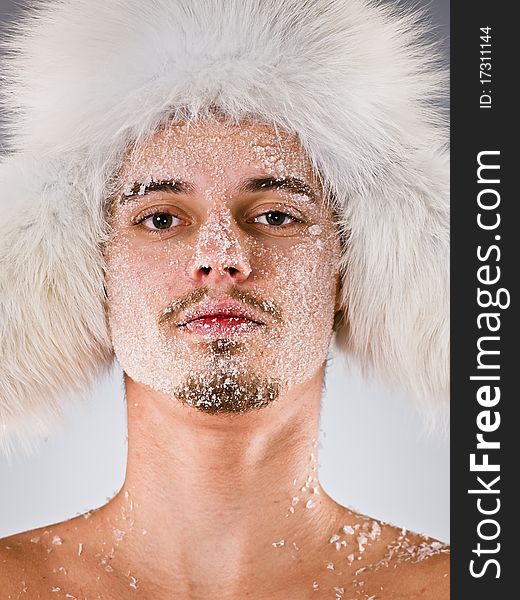 Young man in fur cap with face covered with hoarfrost. Young man in fur cap with face covered with hoarfrost