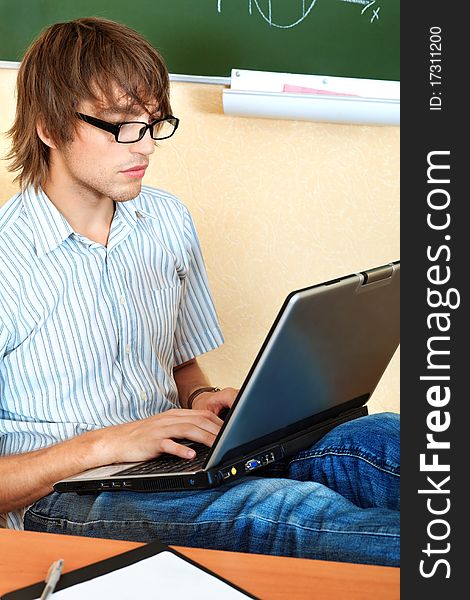 Educational theme: male student in a classroom. Educational theme: male student in a classroom.