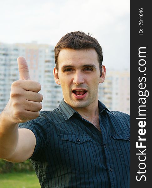 Excited casual young man showing thumb up. Excited casual young man showing thumb up