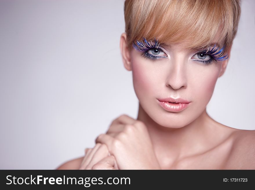 Portrait of a beautiful woman with beautiful makeup isolated on grey