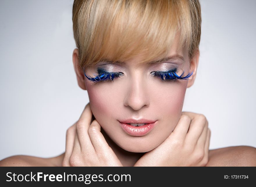 Portrait of a beautiful woman with beautiful makeup isolated on grey