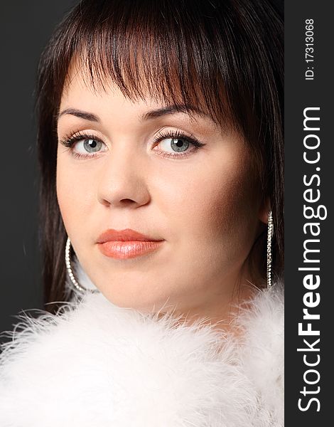 Fashion model girl in white fur on the dark background