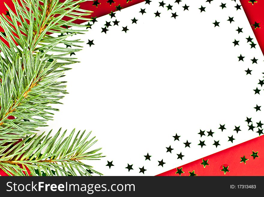 On a red background white greeting card with spruce twigs and green stars. On a red background white greeting card with spruce twigs and green stars.