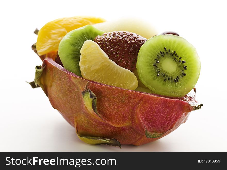 Fruit salad desert in a cuted pitahaya on a white background. Orientation : horizontal Concept and idea : health,healthy food, breakfast,freshness and bio. Fruit salad desert in a cuted pitahaya on a white background. Orientation : horizontal Concept and idea : health,healthy food, breakfast,freshness and bio.